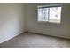 Simple carpeted bedroom with window and neutral walls at 14141 E Jewell Ave # 102, Aurora, CO 80012