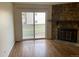 Living room with hardwood floors, stone fireplace, and sliding door to patio at 14141 E Jewell Ave # 102, Aurora, CO 80012