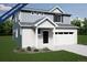 Charming two-story home featuring a covered porch and a two-car garage, set against a backdrop of lush greenery at 3928 N Riviera Ct, Aurora, CO 80019