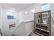 Bright stairway featuring carpeted steps, a metal shelving unit, and natural light from three windows at 3928 N Riviera Ct, Aurora, CO 80019