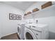 Modern laundry room with Samsung washer and dryer units, a white shelf, and decor at 3928 N Riviera Ct, Aurora, CO 80019