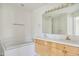 Bathroom featuring a soaking tub and double sink vanity with lots of counter space at 2660 S University Blvd # I, Denver, CO 80210