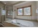 Bright bathroom featuring a large tub with tile surround and glass shower with large window at 89 Fairview Cir, Breckenridge, CO 80424