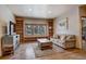 Comfortable living room featuring built-in bookshelves and large windows overlooking a snowy landscape at 89 Fairview Cir, Breckenridge, CO 80424