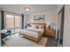 Modern bedroom with a wood bed frame, stylish lamps, and a sliding door leading to a patio at 558 N Washington St # 103, Denver, CO 80203