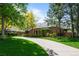 Beautiful brick home with mature trees, large front lawn, and a long driveway at 5851 S Colorado Blvd, Greenwood Village, CO 80121