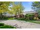 Lovely brick home with mature trees, manicured lawn, and a long driveway at 5851 S Colorado Blvd, Greenwood Village, CO 80121