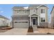 Attractive two-story home boasts stone accents, gray siding, and a well-maintained front lawn at 24008 E Atlantic Pl, Aurora, CO 80018