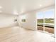 Bright living room featuring a sliding glass door and multiple windows overlooking the lawn at 24008 E Atlantic Pl, Aurora, CO 80018