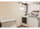 Functional laundry room with modern white appliances, a small window, and a decorative rug at 7926 S Corona Ct, Centennial, CO 80122