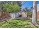 Backyard shed with grill on a sunny lot surrounded by a wood fence at 7926 S Corona Ct, Centennial, CO 80122