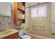 Bathroom with pink tub, wood cabinets and tile accent wall at 2683 E 90Th Pl, Thornton, CO 80229