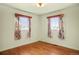 Bedroom with two windows, wood trim and hardwood floors at 2683 E 90Th Pl, Thornton, CO 80229