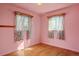 Pink bedroom with two windows, wood trim and hardwood floors at 2683 E 90Th Pl, Thornton, CO 80229