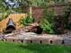 Beautiful backyard featuring a custom rock pond, metal fireplace and brick retaining wall at 5884 S Hanover Way, Greenwood Village, CO 80111
