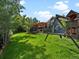 Expansive backyard with lush lawn, wooden deck, and wooden playset for outdoor enjoyment at 5884 S Hanover Way, Greenwood Village, CO 80111