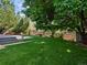 Beautifully landscaped backyard featuring a multi-level deck, brick retaining wall, and mature trees at 5884 S Hanover Way, Greenwood Village, CO 80111