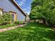 Backyard features a well-manicured lawn, stone retaining wall and flourishing greenery at 5884 S Hanover Way, Greenwood Village, CO 80111