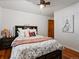 Comfortable bedroom with a decorative comforter, wood floors, a ceiling fan, and a bedside table with lamp at 5884 S Hanover Way, Greenwood Village, CO 80111