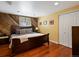 Cozy bedroom featuring wood accent wall, hardwood floors, and natural light from the window at 5884 S Hanover Way, Greenwood Village, CO 80111