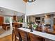 Open-concept dining area features a stone fireplace, wood floors, and seamless access to kitchen and living area at 5884 S Hanover Way, Greenwood Village, CO 80111