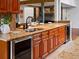 Kitchen counter with gorgeous stone countertop, undermounted wine fridge, stainless steel sink, and wood cabinets at 5884 S Hanover Way, Greenwood Village, CO 80111