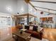 Open-concept living room with a cozy leather sofa, beams, fireplace, and a connecting kitchen at 5884 S Hanover Way, Greenwood Village, CO 80111