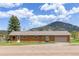 Ranch-style home featuring a front yard, attached garage, and serene mountain views at 26063 Morris Ave, Conifer, CO 80433