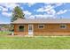 Close-up of a ranch home with a charming front door, a grassy lawn, and mountain views at 26063 Morris Ave, Conifer, CO 80433