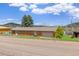 Quaint ranch home featuring an attached garage, surrounded by mature trees and scenic mountains at 26063 Morris Ave, Conifer, CO 80433