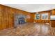Open living room with wood accents, an inviting stone fireplace, and views to the kitchen at 26063 Morris Ave, Conifer, CO 80433