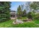 Beautiful backyard with lush landscaping, a pond, a covered patio, and a fire pit, perfect for relaxation at 7100 S Hudson Cir, Centennial, CO 80122