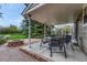 Covered patio boasts a table with chairs, perfect for outdoor dining, and a stone fire pit at 7100 S Hudson Cir, Centennial, CO 80122