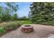 Stone fire pit surrounded by lush greenery and landscaping, creating a serene outdoor space at 7100 S Hudson Cir, Centennial, CO 80122