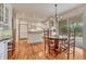 Bright kitchen with wood floors, white cabinetry, center island, stainless steel appliances, and breakfast nook at 7100 S Hudson Cir, Centennial, CO 80122