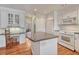 Open kitchen with granite island, white cabinets, built-in desk, and stainless steel appliances at 7100 S Hudson Cir, Centennial, CO 80122