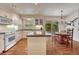 Open concept kitchen features white cabinets, granite countertops, a center island, and a connected breakfast nook at 7100 S Hudson Cir, Centennial, CO 80122