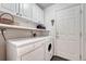Bright laundry room featuring a washer, dryer, overhead cabinets, and a practical utility sink at 7100 S Hudson Cir, Centennial, CO 80122