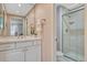 Bright bathroom with a double sink vanity, a large mirror, and a glass-enclosed shower at 7100 S Hudson Cir, Centennial, CO 80122