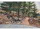Secluded backyard featuring a waterfall, lush landscaping, and seating under a canopy of mature trees at 814 Neville Ln, Golden, CO 80401
