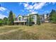 Stunning gray home featuring a stone chimney, rounded tower, walk out basement and balconies, all nestled among mature trees at 814 Neville Ln, Golden, CO 80401