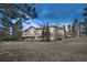 Expansive backyard view of a custom home, showing the manicured lawn and large windows showcasing the interior at 814 Neville Ln, Golden, CO 80401