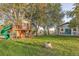 Playful backyard with a treehouse, slide, and large lawn at 10876 Maple Rd, Lafayette, CO 80026