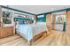 Bedroom with barn door entry to en-suite bathroom and light wood floors at 10876 Maple Rd, Lafayette, CO 80026