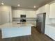 Modern kitchen featuring white cabinetry, stainless steel appliances, and a large kitchen island at 12883 Range St, Firestone, CO 80504