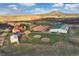 Expansive property featuring a house, horse barn, riding arena, and round pens against a backdrop of rolling hills at 5351 Tall Horse Trl, Sedalia, CO 80135