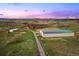A stunning aerial view of the sprawling horse property at sunset at 5351 Tall Horse Trl, Sedalia, CO 80135