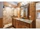 Bathroom featuring wood paneling, a granite countertop, and a tile shower, exuding rustic elegance at 5351 Tall Horse Trl, Sedalia, CO 80135