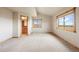 Bright bedroom featuring neutral walls, soft carpeting, bright windows with stunning view, and an ensuite bathroom at 5351 Tall Horse Trl, Sedalia, CO 80135