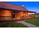 Charming log cabin with a red roof and inviting porch, set against a backdrop of rolling hills at 5351 Tall Horse Trl, Sedalia, CO 80135
